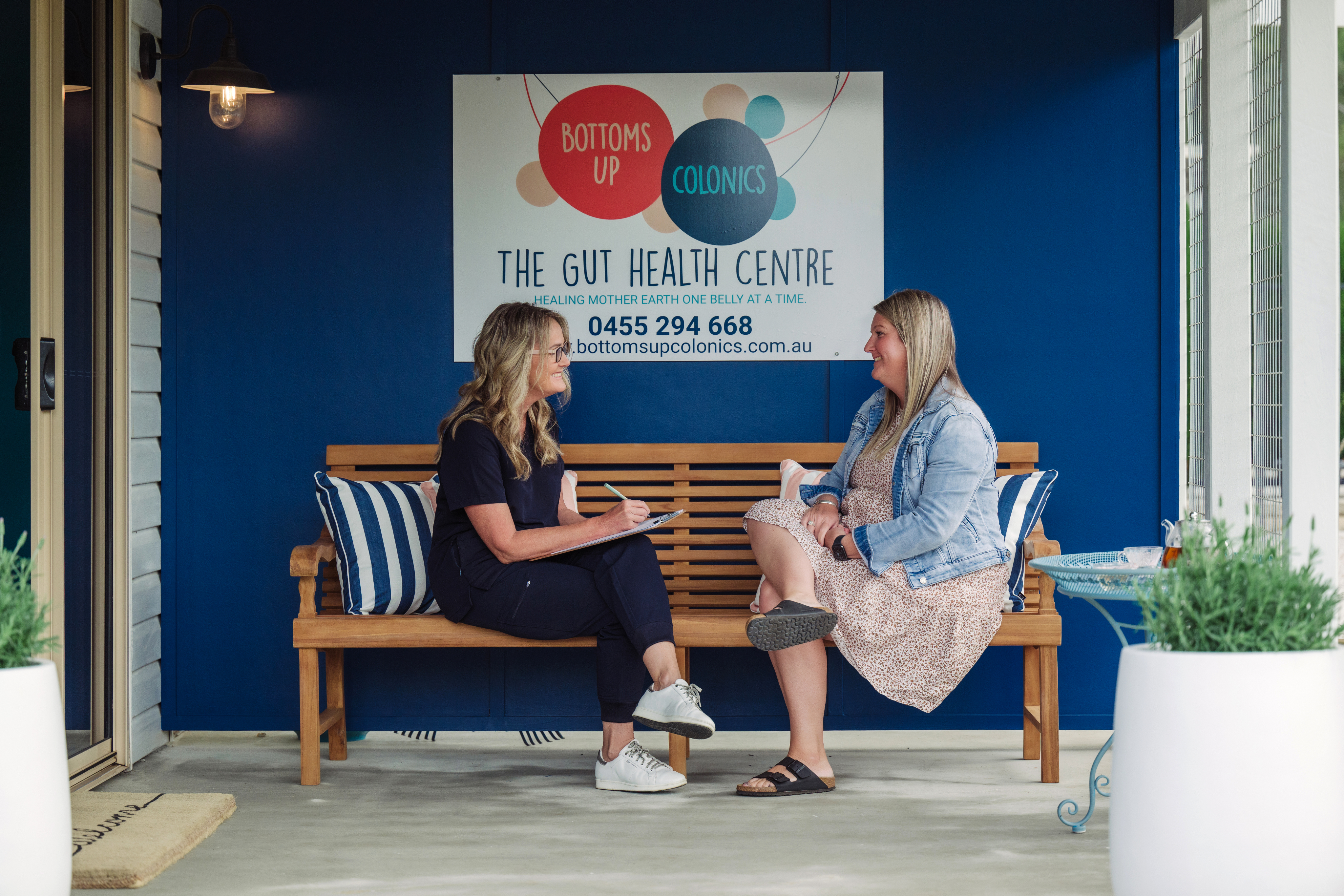 Two women sitting on a bench at Bottoms Up Colonics clinic